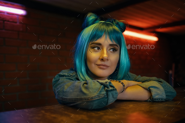 Girl in nightclub listening to to somebody while sitting at table - Stock Photo - Images