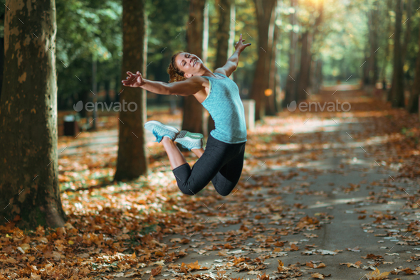 Woman Doing Star Jump Outdoors Stock Photo by microgen | PhotoDune