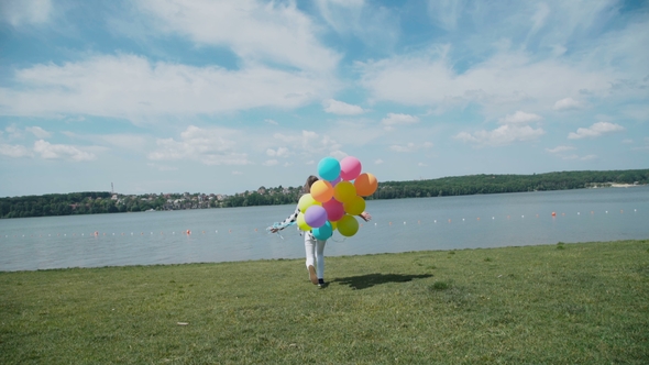 Pretty Girl Runs To the River Bay with Colourful Balloons