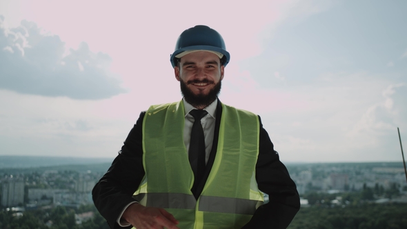 Happy Young Businessman on Top of the Construction Site alt