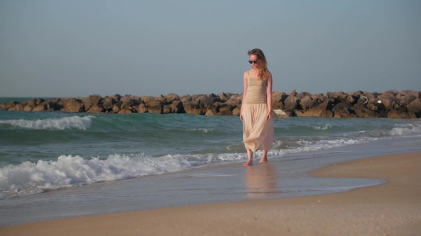 Graceful Blonde Girl Is Walking Over Sand Beach