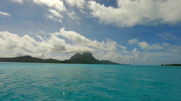 Sailing with a dingi over the ocean in front of Bora Bora in French Polynesia alt