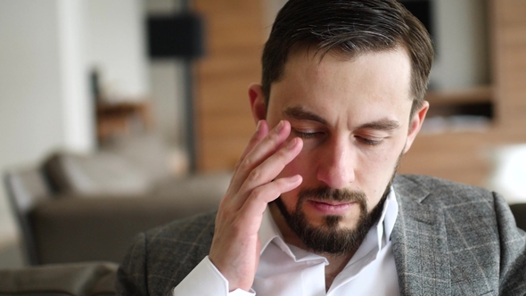 Portrait of Tired Young Businessman Touches His Head with Hand, alt