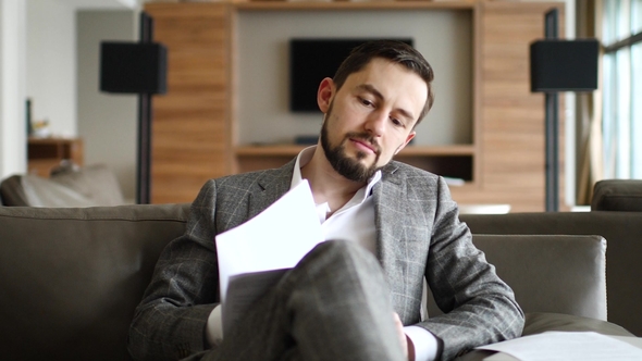 Businessman Looking Documents Sitting on the Couch in the Lounge Room alt