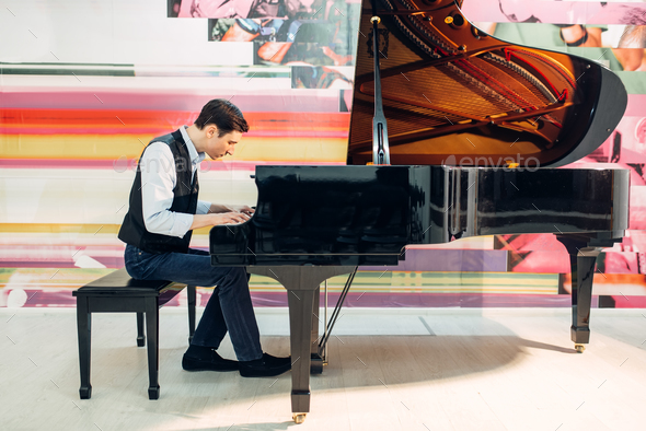 Male pianist practicing composition on grand piano Stock Photo by NomadSoul1