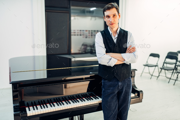Male pianist stands at the black grand piano Stock Photo by NomadSoul1