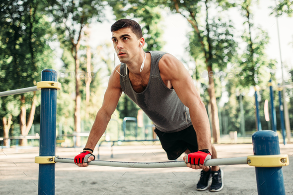 Man doing push-up exercise using horizontal bar - Stock Photo - Images