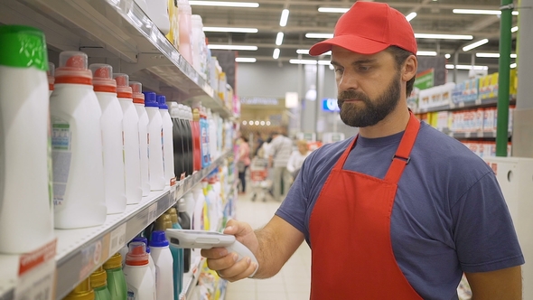 Supermarket Employee in Red Uniform Scanning Cleaners Barcode in Modern Retail Store
