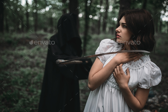 Death swinging a scythe on young female victim - Stock Photo - Images