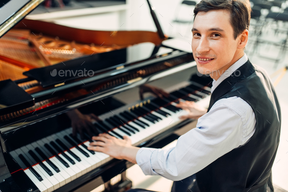 Male pianist poses at the black grand piano Stock Photo by NomadSoul1