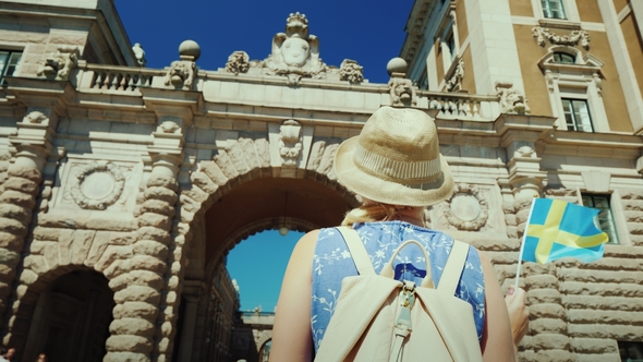Stockholm, Sweden: A Female Tourist with a Swedish Flag Goes To the Arch Near the Parliament. One of alt