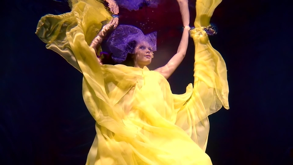 A Beautiful Girl in a Long Yellow Dress Hovers Like an Angel Underwater Like alt