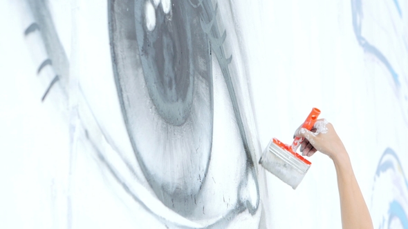 Graffiti Artist Drawing with White Paint On Street Wall. Female Hand with Brush. Urban Outdoors Art alt