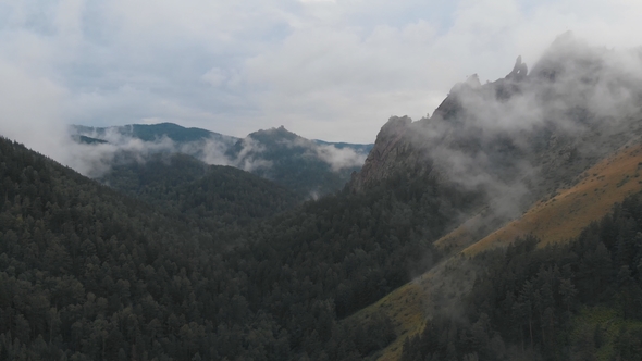 Aerial View of Fog Among the Mountain Peaks. Bad Weather and Fog in the Siberian Nature Reserve alt