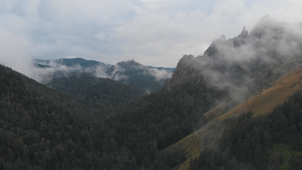 Aerial View of Fog Among the Mountain Peaks. Bad Weather and Fog in the Siberian Nature Reserve