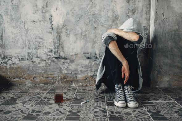 Druggy sitting on the floor, withdrawal symptom - Stock Photo - Images