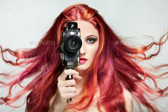 Beautiful young woman using a retro video camera Stock Photo by heckmannoleg