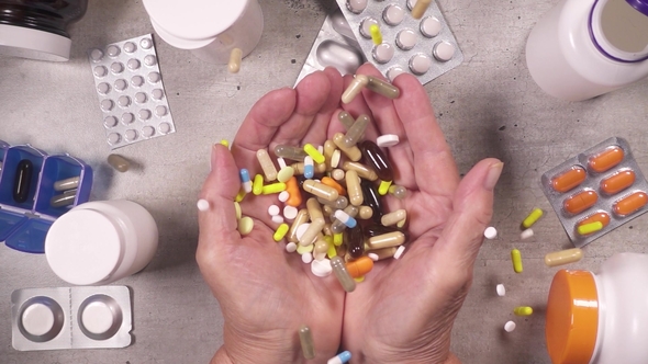 Pile of Pills Falls on the Open Palms Top View