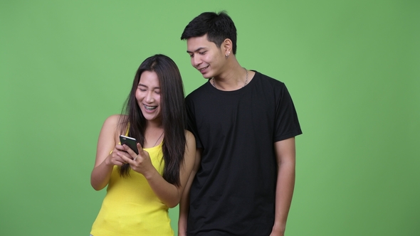 Young Happy Asian Couple Using Phone Together alt