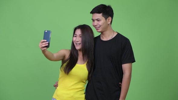 Young Happy Asian Couple Taking Selfie Together, Stock Footage | VideoHive