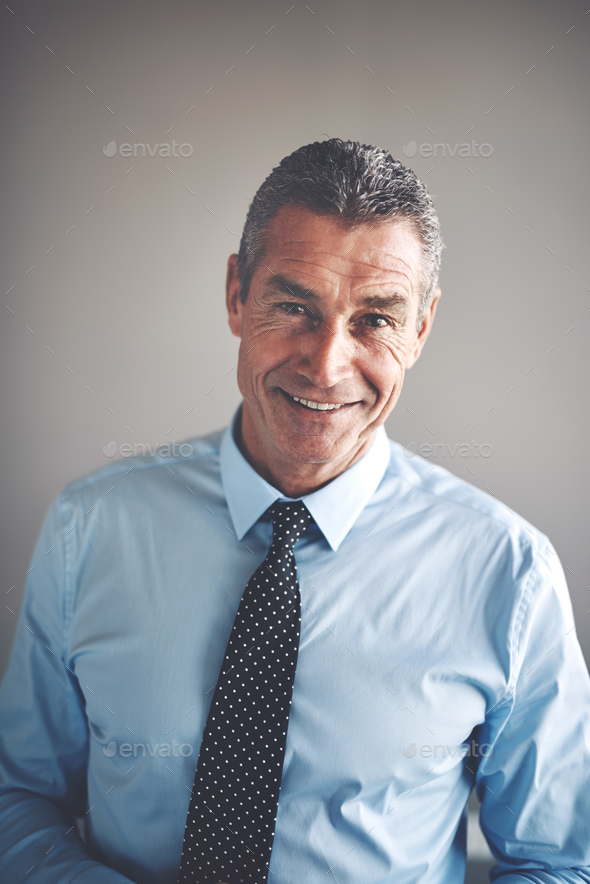 Smiling mature corporate executive wearing a shirt and tie - Stock Photo - Images