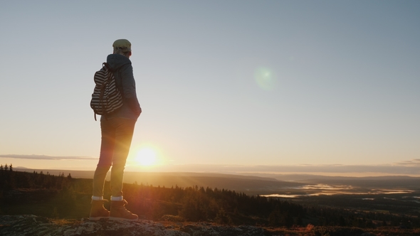 A Woman Traveler Stands on Top of a Mountain, Looks at the Beautiful Landscape Ahead alt