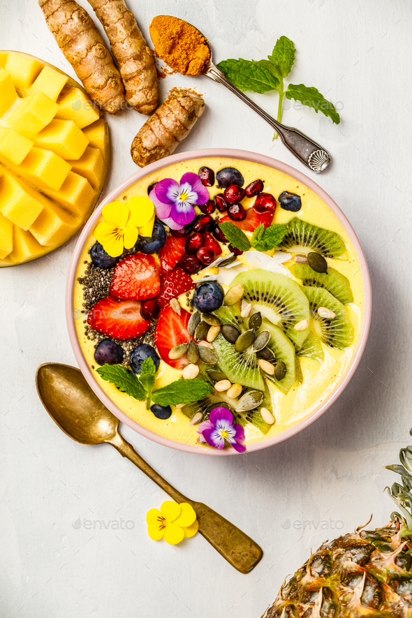 Mango banana pineapple turmeric smoothie bowl - Stock Photo - Images