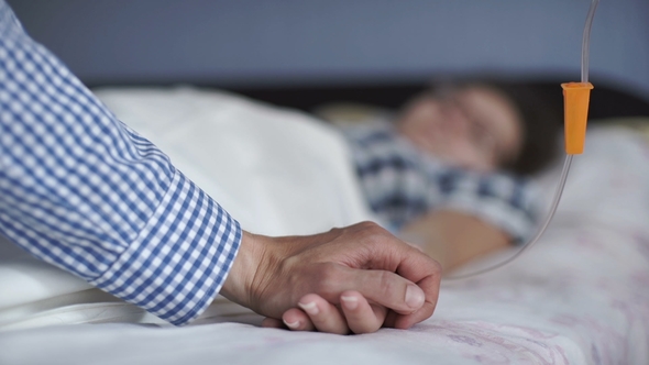 A Man Calming a Woman in a Hospital, Holding Her Hand