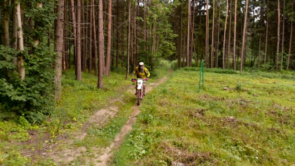 Enduro Motorcyclist Riding Alone in Remote Woods alt