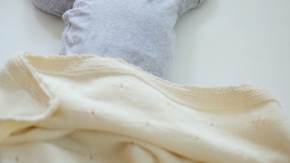 Mother Cover Her Baby with a Blanket in a White Bed, Warm Concept and Healthcare