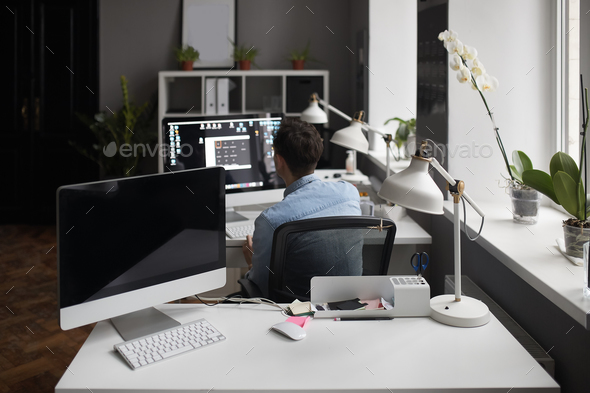 Young intelligent bearded man working at modern loft studio-offi - Stock Photo - Images