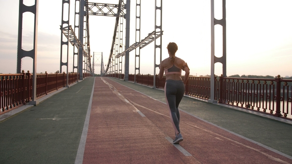 Senior Female Runner on Morning Workout on Bridge alt