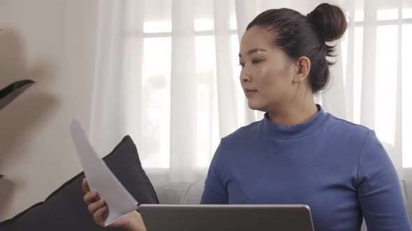 New normal businesswoman work from home by laptop sitting on the sofa happily alt