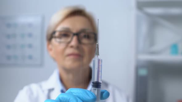 Serious Female Doctor Showing Syringe at Camera, Vaccine Injection, Medicine