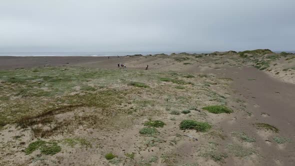 Drone Flying Low Over Wide Sandy Land Where People Searching Place For Camping Beside The Sea , Cali alt