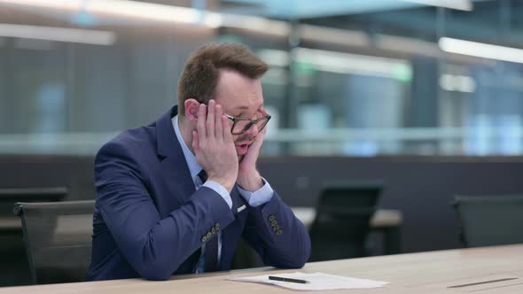 Middle Aged Businessman Reacting to Loss While Reading Documents alt