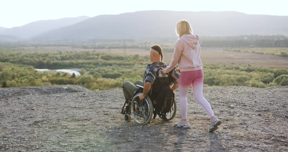 Attractive Happy Modern Couple in Love Where Handsome Disabled Man in Wheelchair and His Blond Wife alt