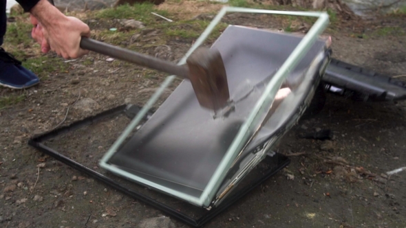 Man Swings Sledge Hammer Into Printer, Computer and Monitor on Nature Background with Grasss alt