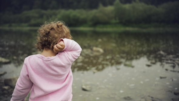 Blonde Curly Little Girl Throw Stones in the River
