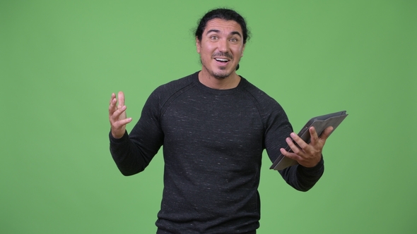 Handsome Man Using Digital Tablet and Looking Surprised alt