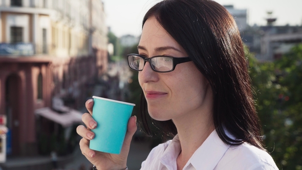 Successful Businesswoman Looking Into Distance, Drinking Coffee and Enjoying