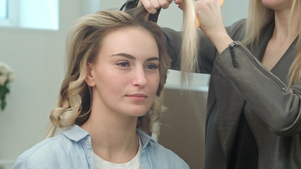 Professional Hair Stylist Doing Hairstyle of Beautiful Blond Model and She Smiling alt