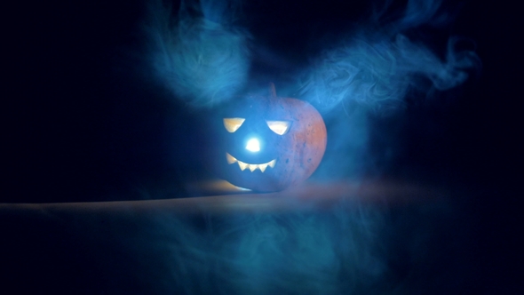 Dark Room with Clouds of Mist and a Glowing Jack-o-lantern alt