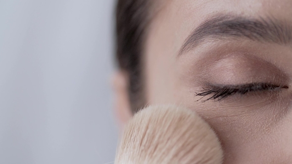 Face Makeup.  Woman With Closed Eye Powdering Skin alt