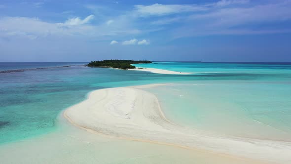 Unspoiled white sandy stripe beach washed by calm clear water of turquoise lagoon near beautiful tin alt