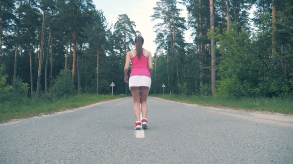 Young Woman Starts Running Along the Road. Female Athlete Jogging alt