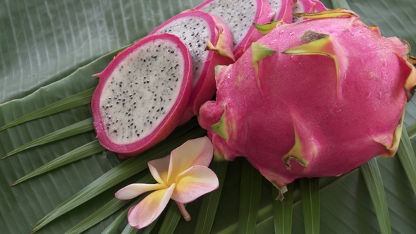 Two Fresh Raw Exotic Tropical Thai Dragon Fruit Also Called Pitayas Rotating on Banana Leaf alt