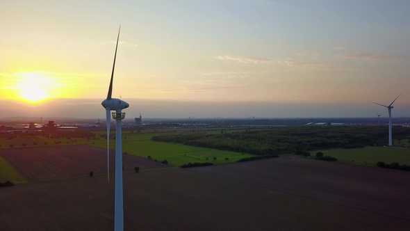 Aerial Footage of a Wind Turbine in Front of the Setting Sun Wind Power - Circling Around Wind