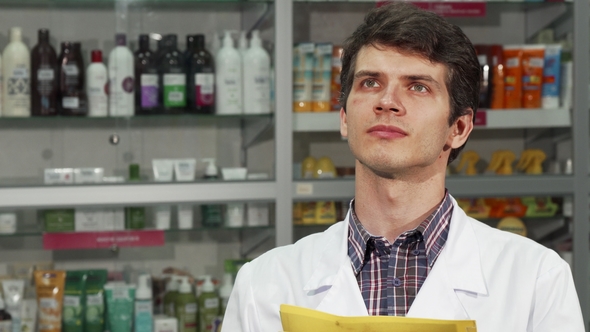 Male Pharmacist Doing Inventory at the Drugstore alt