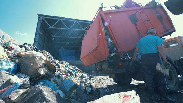 Litter Is Getting Discarded From a Truck in a Scrapyard alt